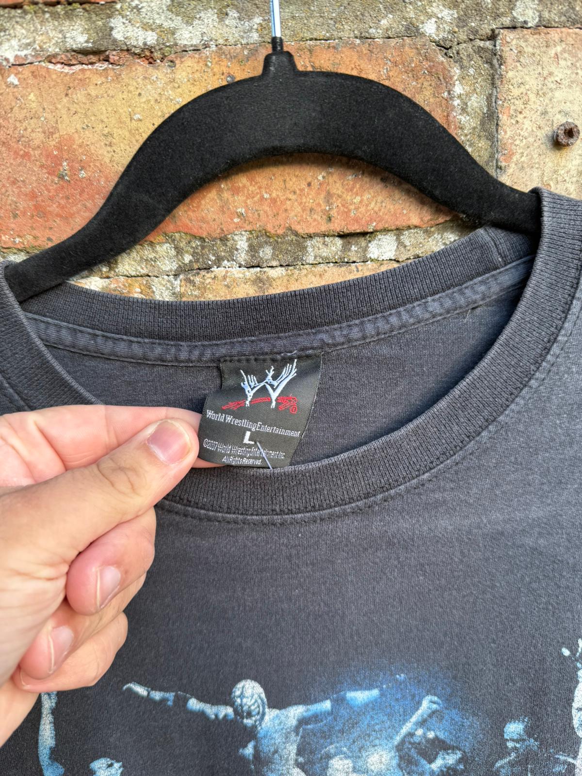 Black t-shirt with graphic design and close-up of black WWE tag