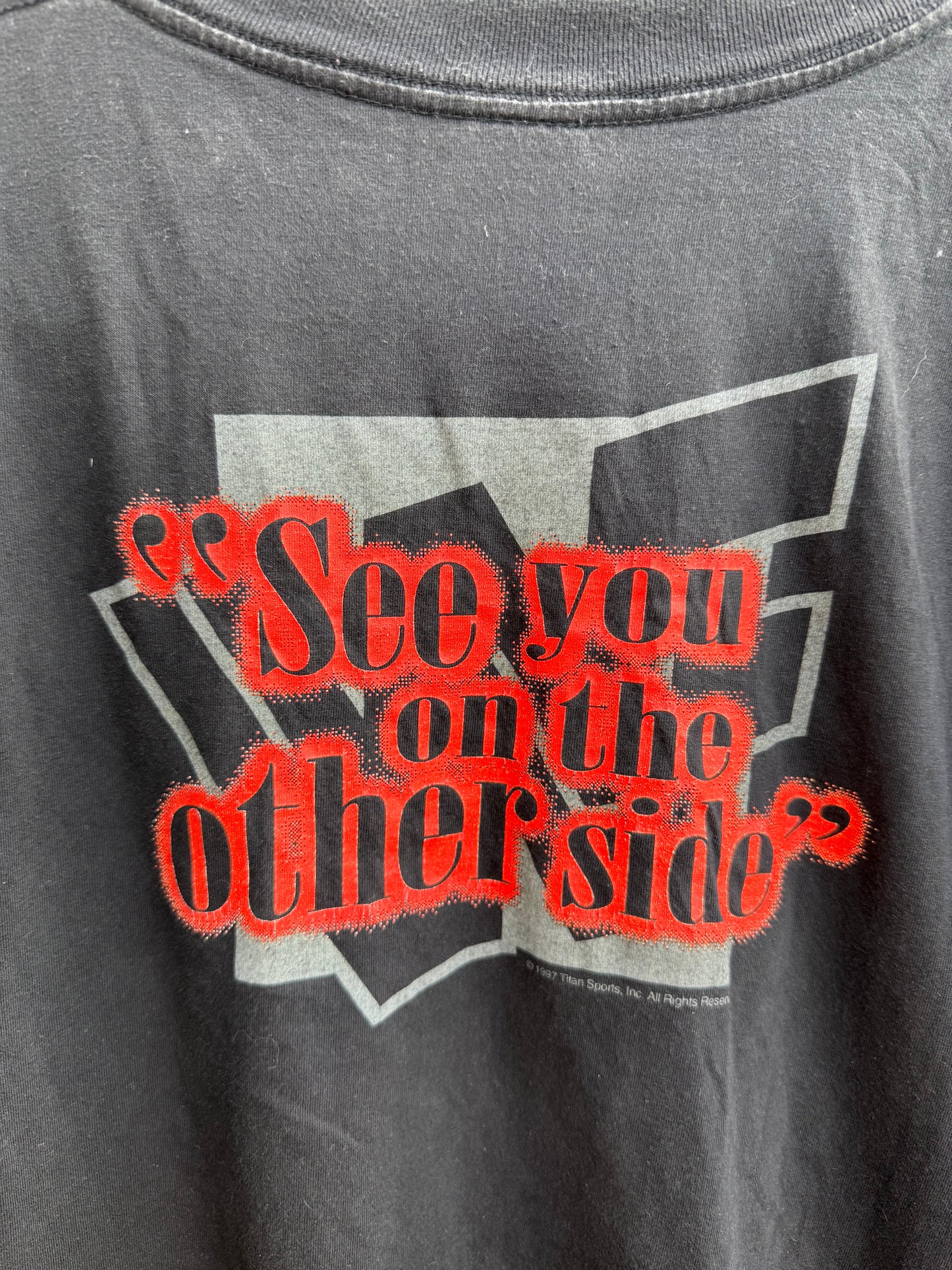 Back of black t-shirt with close=up pf 'ee you on the other side'