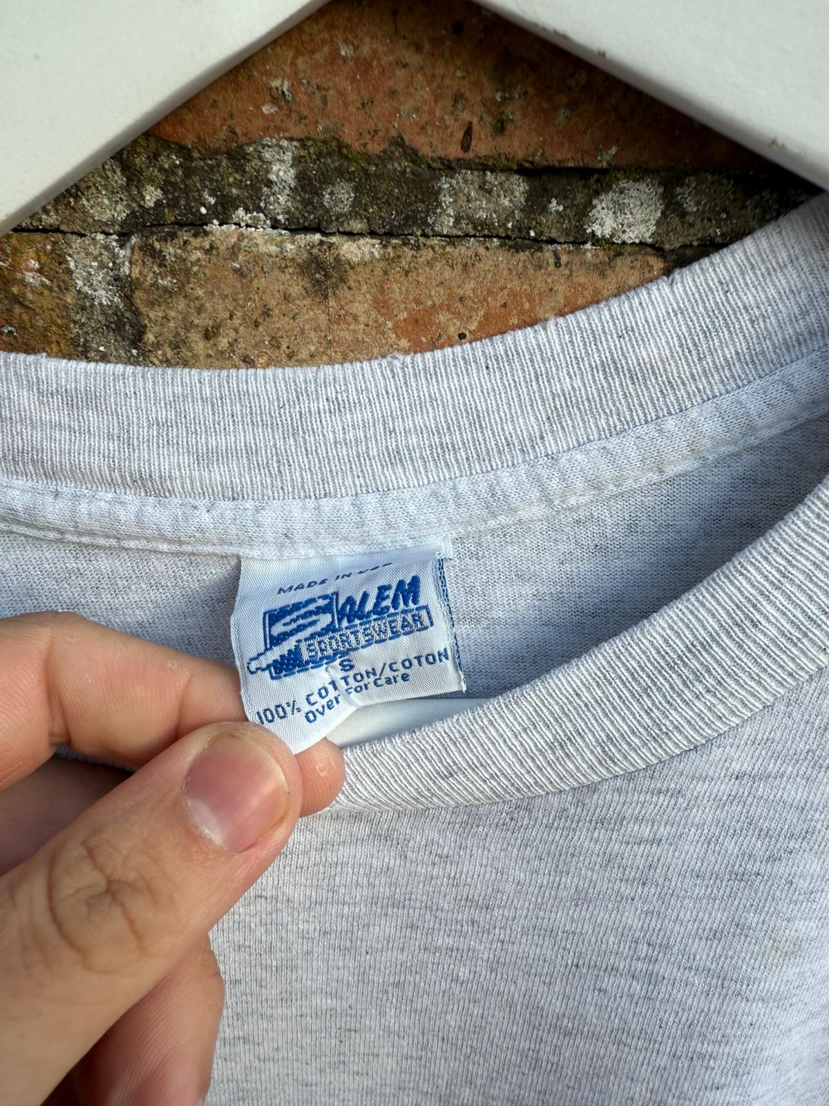 Gray t-shirt with a Salem Sportswear label on a brick surface