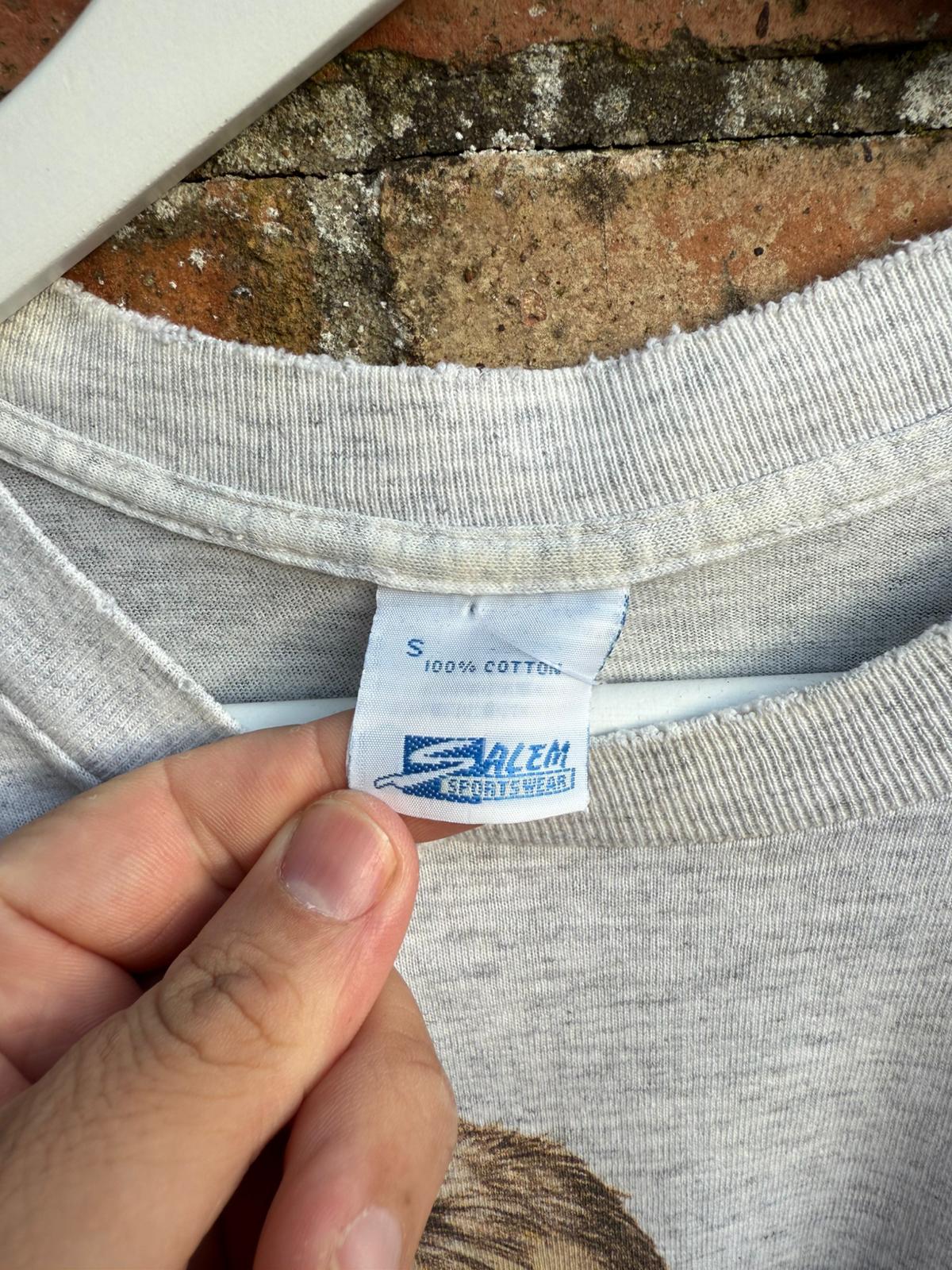 Gray t-shirt with a Salem Sportswear label on a brick surface