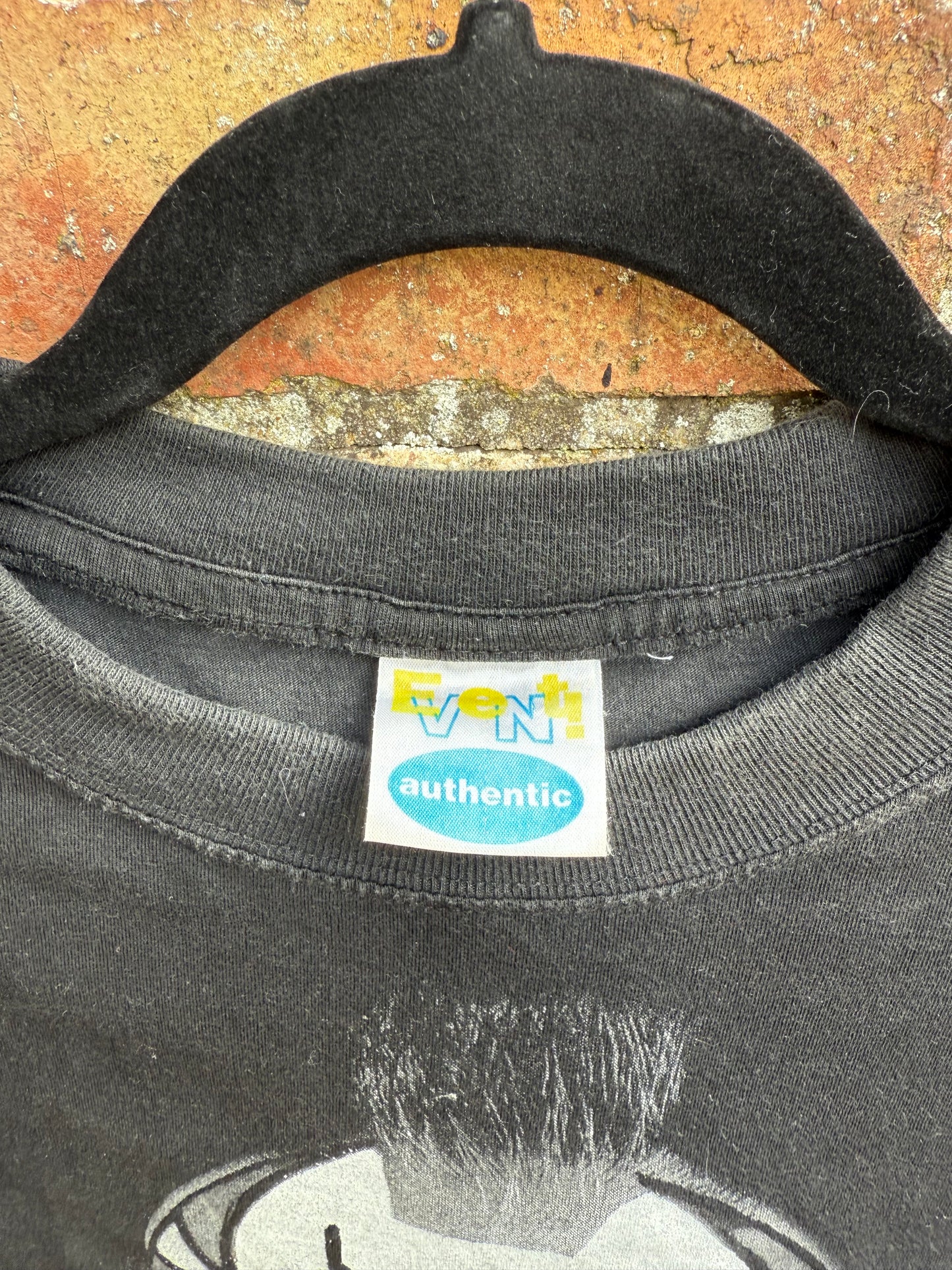 Close-up of an Event Authentic tag on a black t-shirt