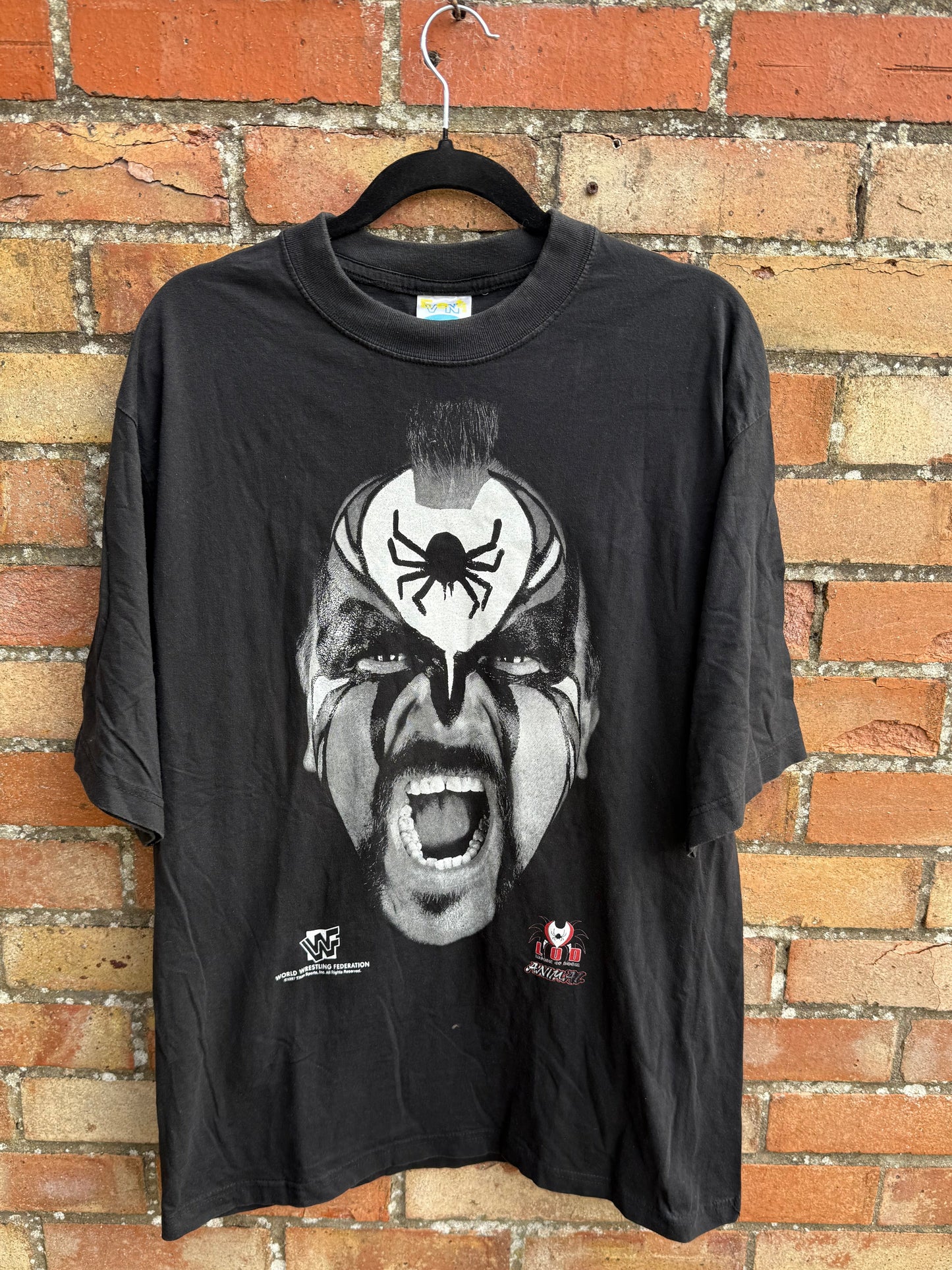 Black t-shirt with graphic design and WWF branding on a brick surface