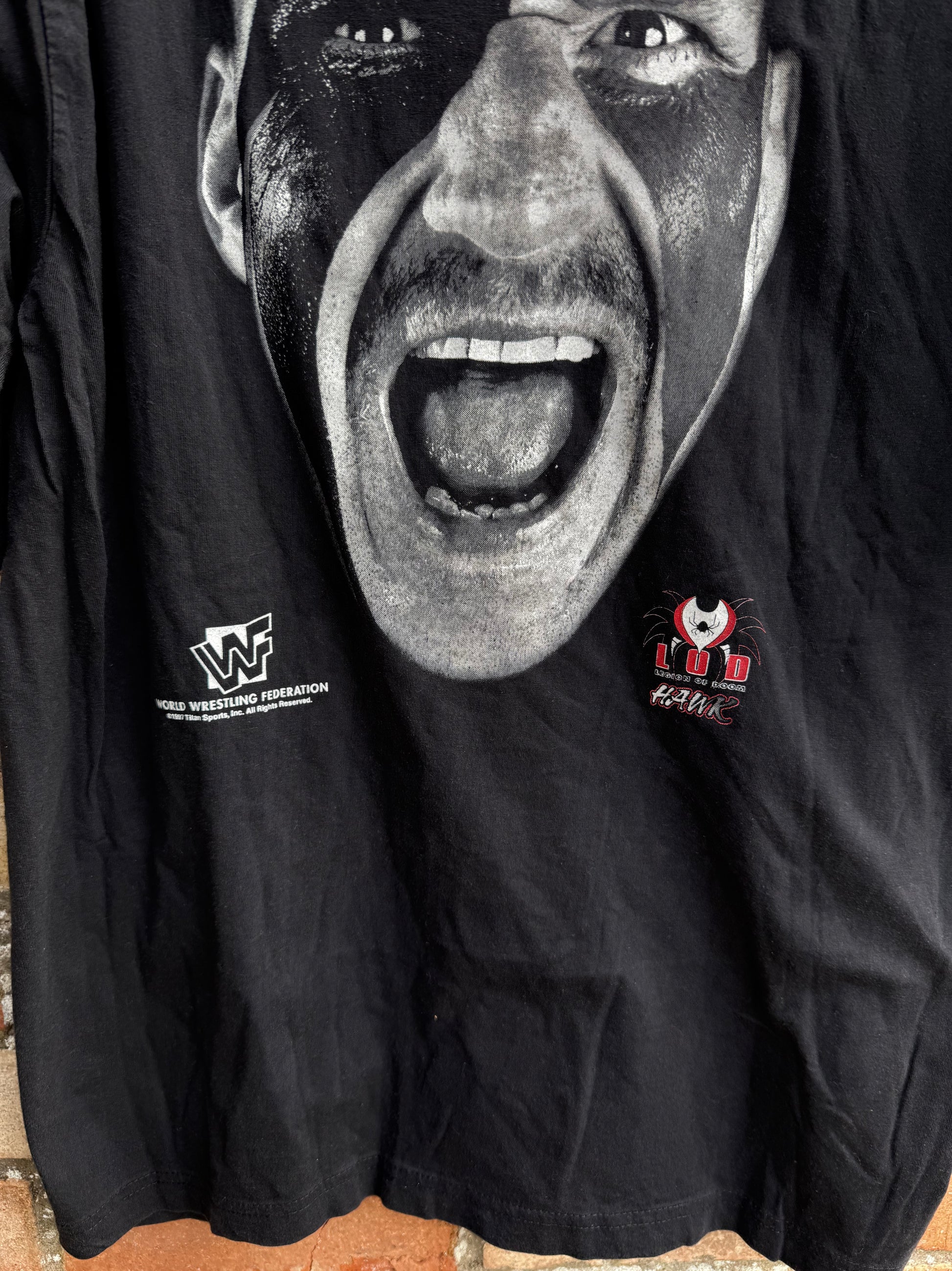 Black t-shirt with face graphic of LOD Haw and WWF logo
