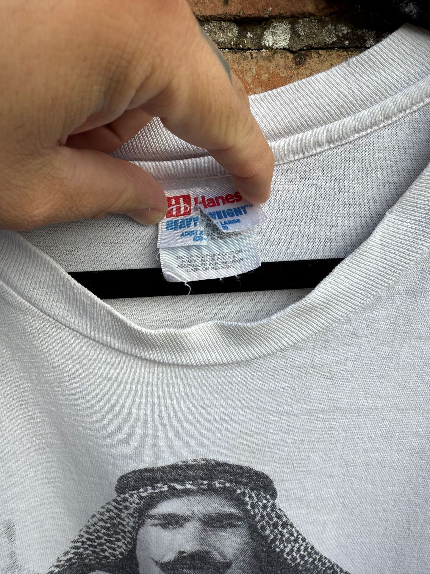 Hanes Heavyweight tag on a white shirt with a graphic of a man wearing a headscarf.
