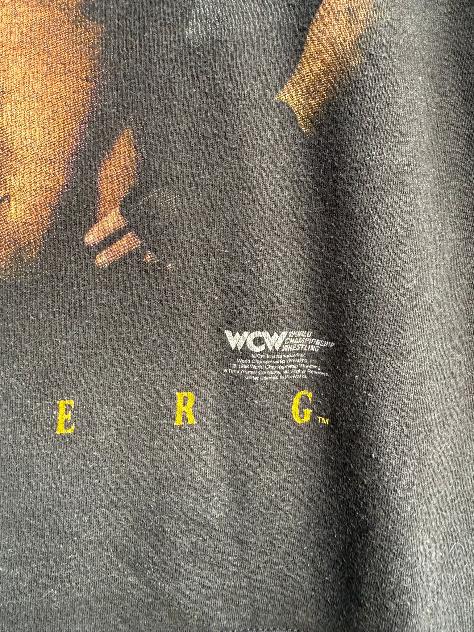 Close-up of a black t-shirt design with 'WCW' branding and yellow text.