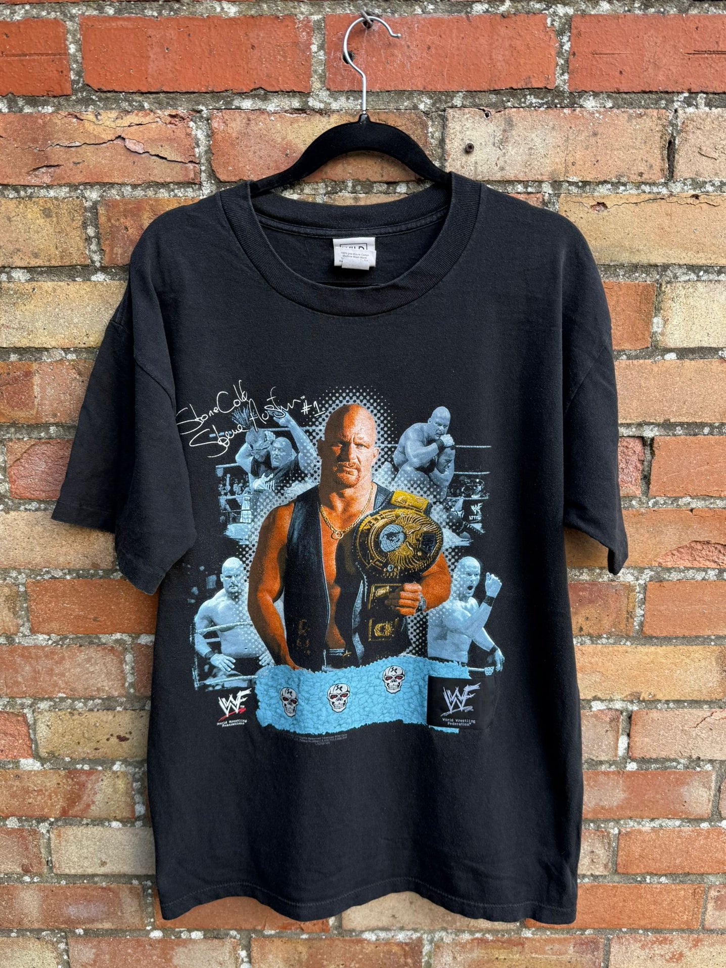 Black t-shirt with graphic design of a wrestler stone Cold Steve Austin holding a championship belt