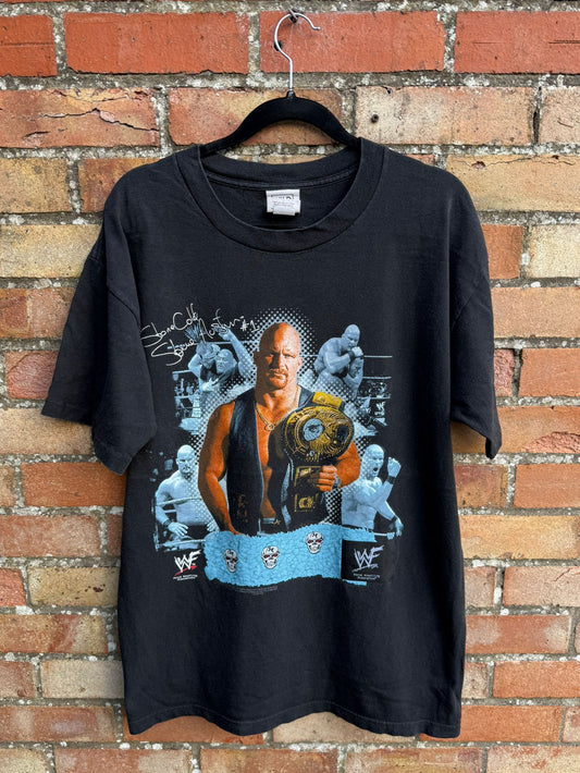 Black t-shirt with graphic design of a wrestler stone Cold Steve Austin holding a championship belt