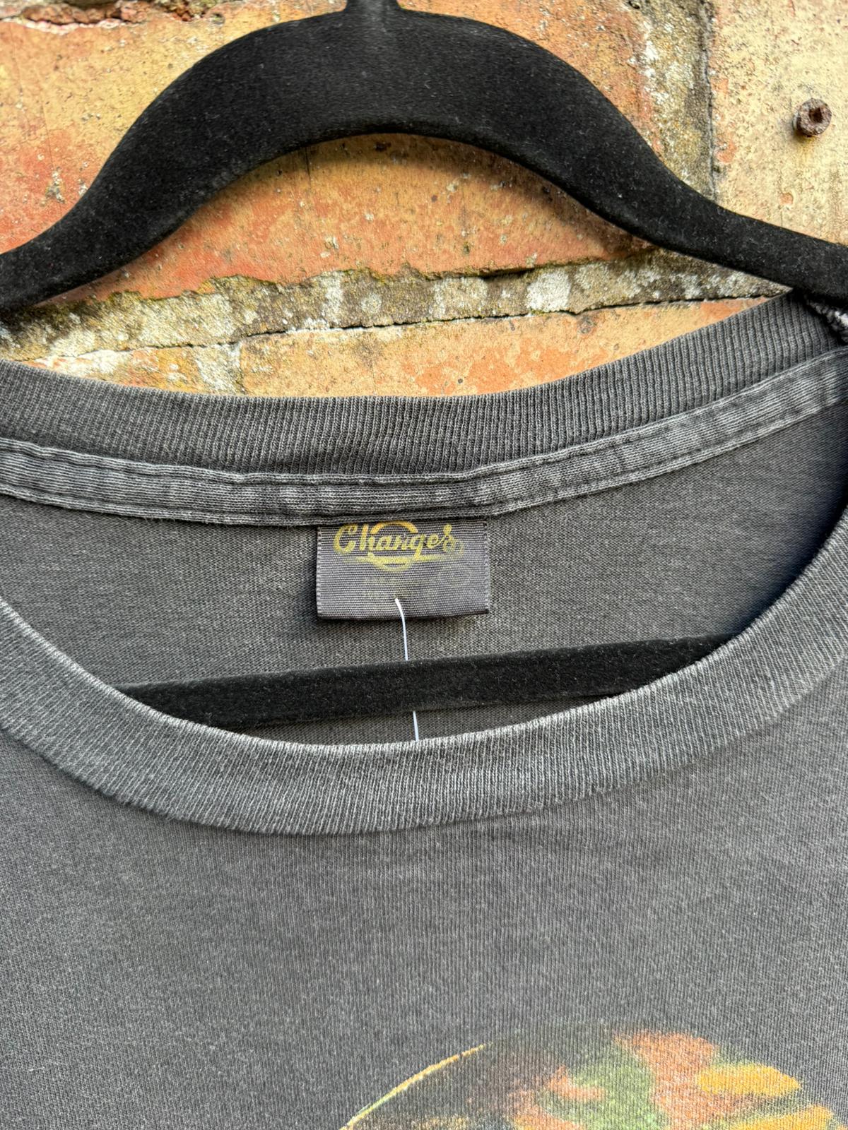 Black t-shirt with a Changes brand label on a brick wall background