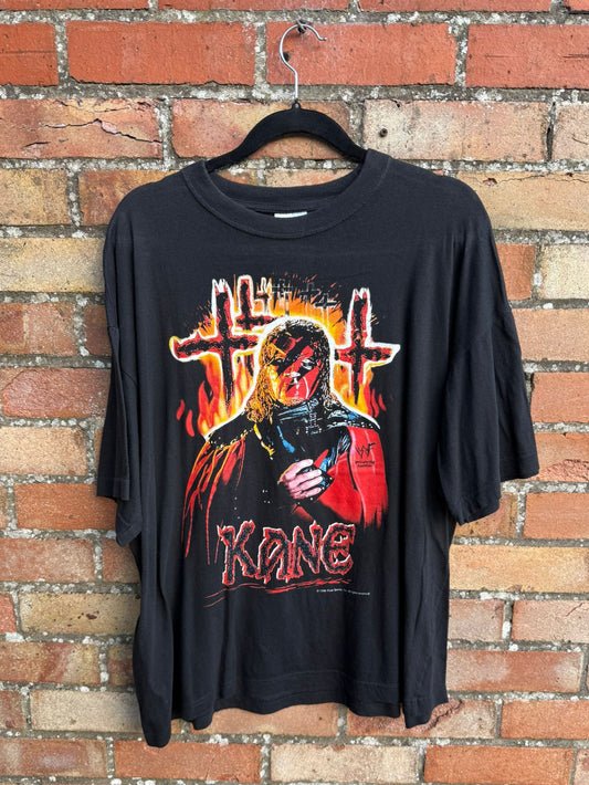 Black t-shirt with Kane and burning crosses hanging against brick wall