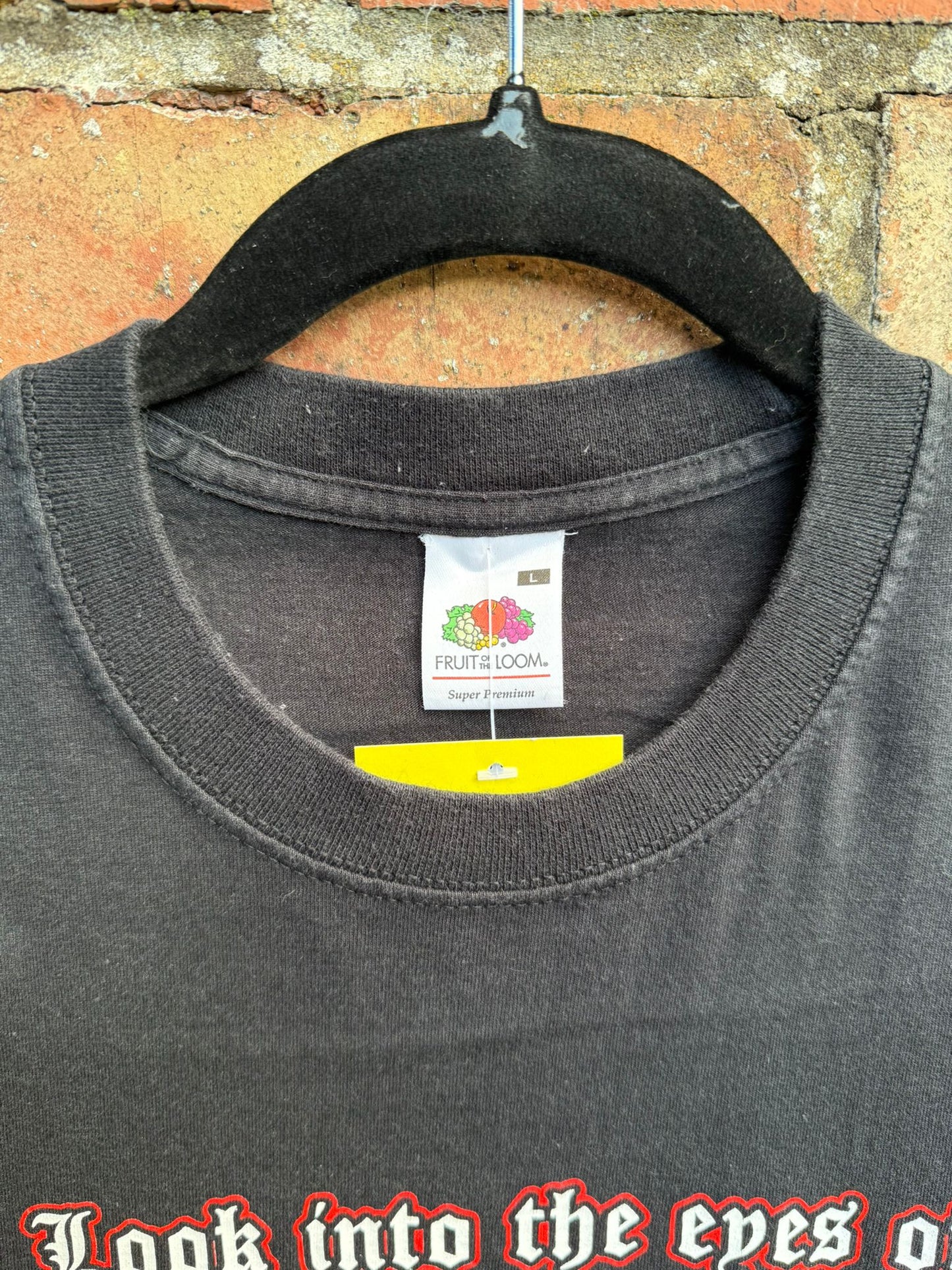 Black t-shirt with Fruit of the Loom tag and text 'Look into the eyes of The Deadman' on a brick wall background