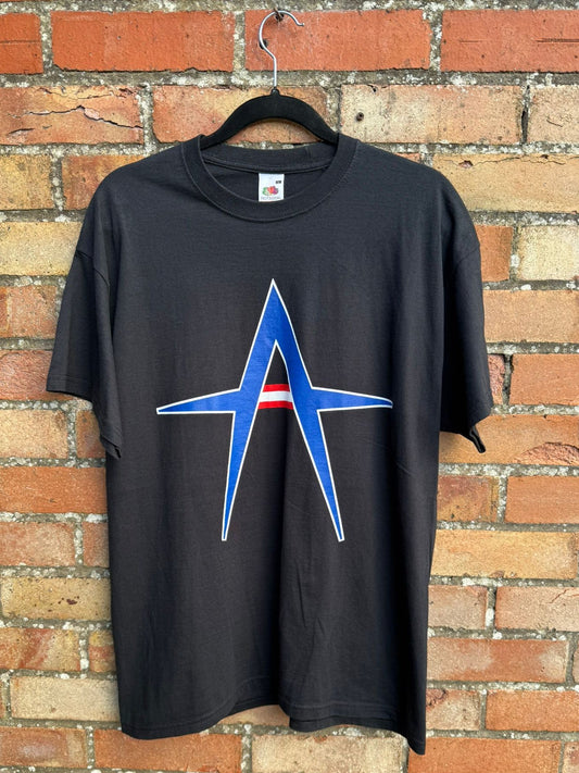 Black t-shirt with a Kurt Angle blue design on a brick wall background