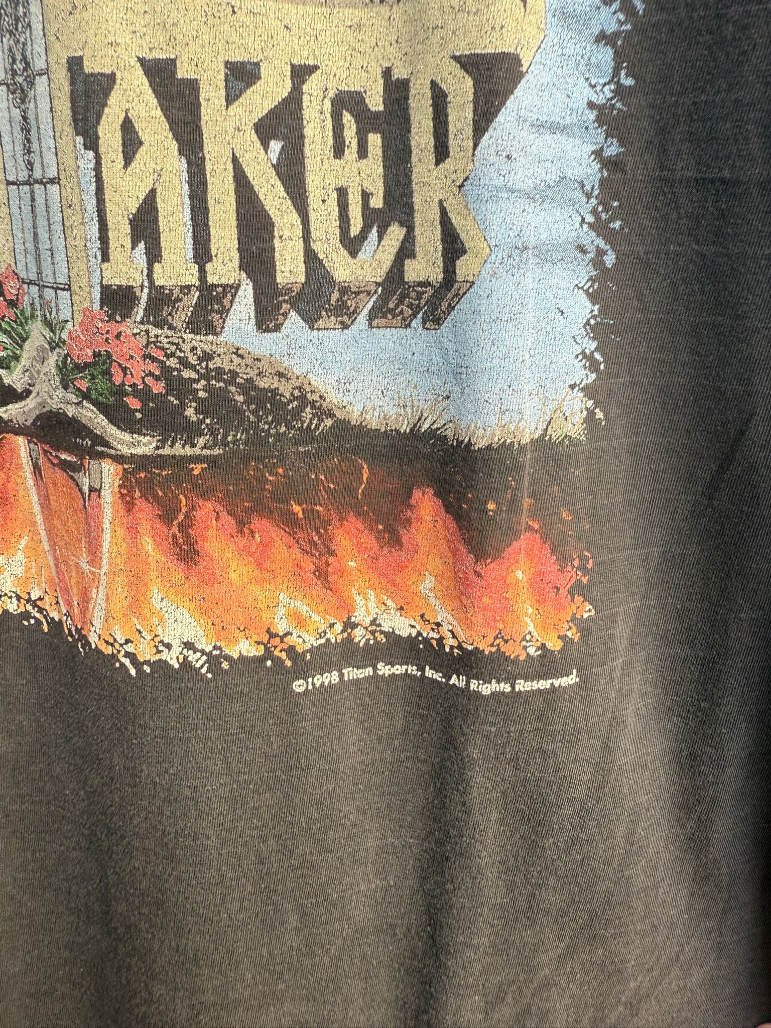 T-shirt with graphic design and Titan Sports 1998 copyright text on a black background