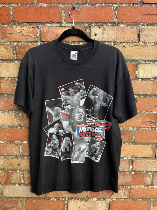 Black t-shirt with Wrestlemania wrestling graphic on a hanger against a brick wall