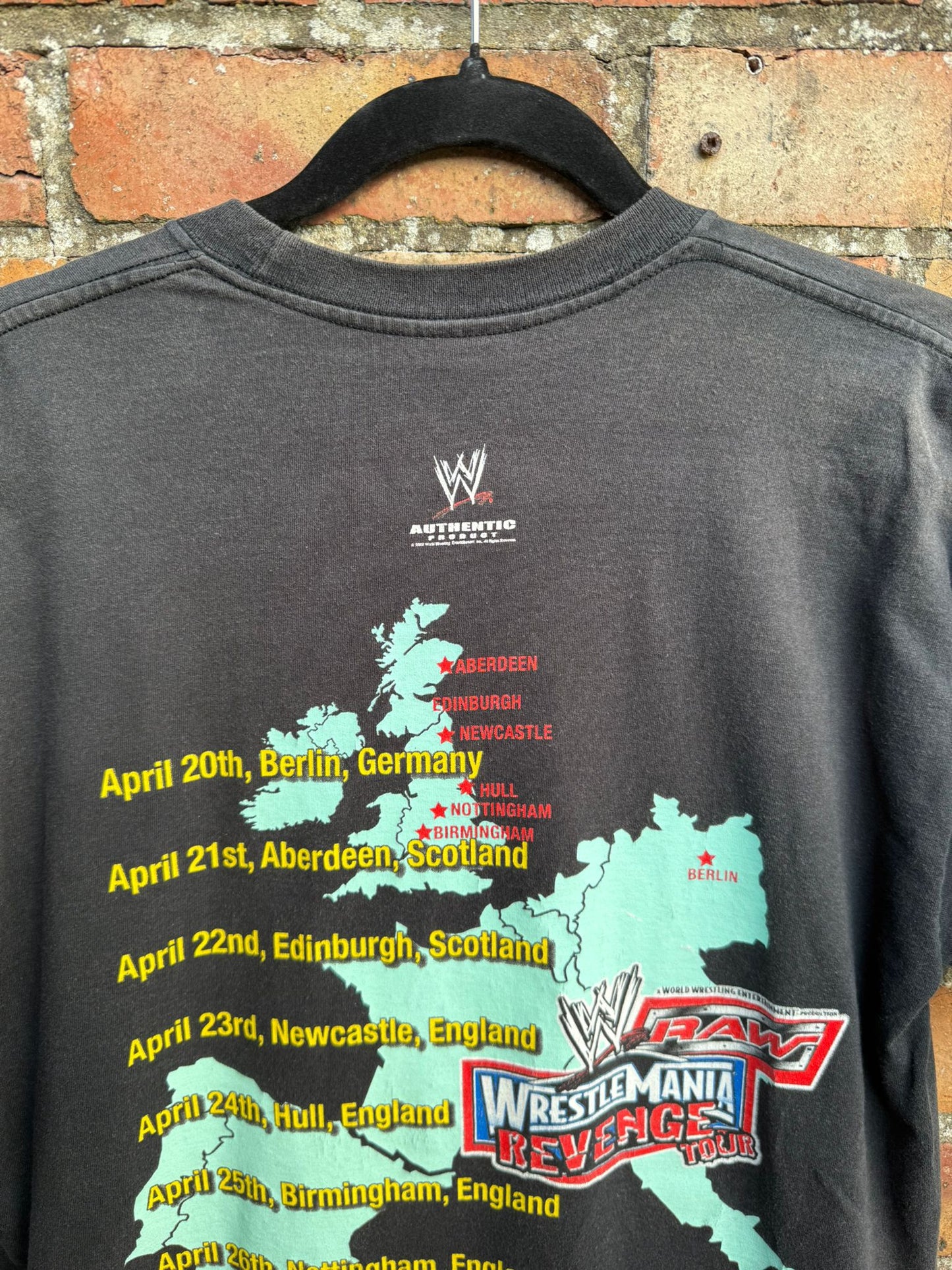 Black t-shirt with WWE graphic and event dates for Wrestlemania Revenge Tour