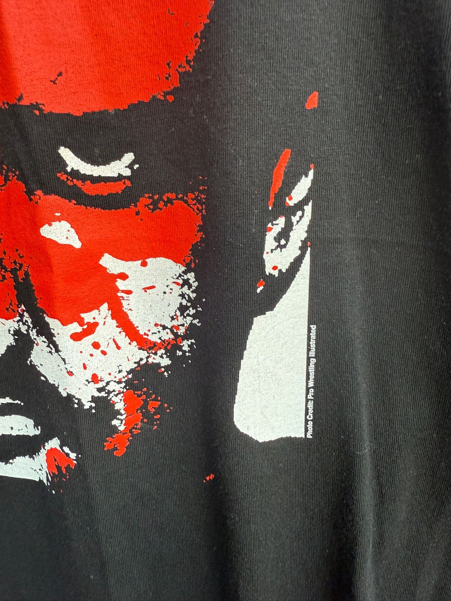 Black t-shirt with a red and white graphic design of a face on a black t-shirt