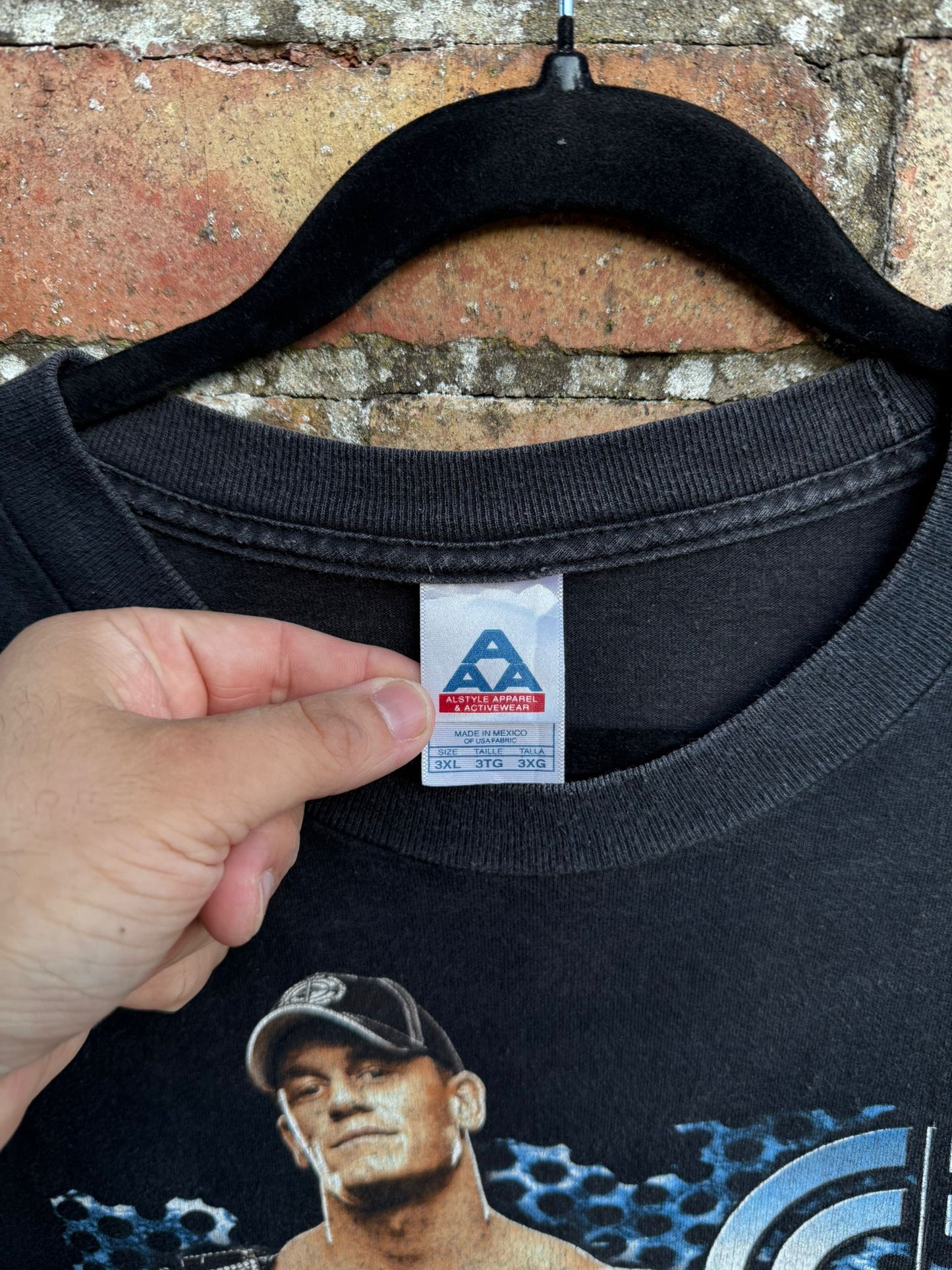 Close-up of a clothing tag AAA in 3XL on a black t-shirt