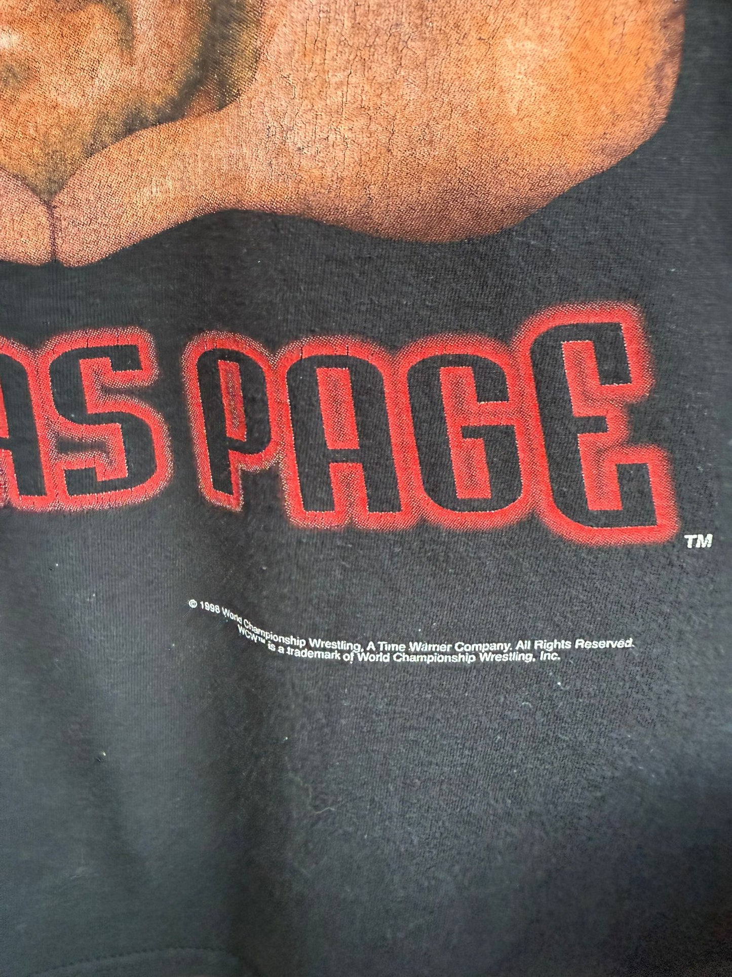 Close up of black t-shirt area showing branding for WCW 1998