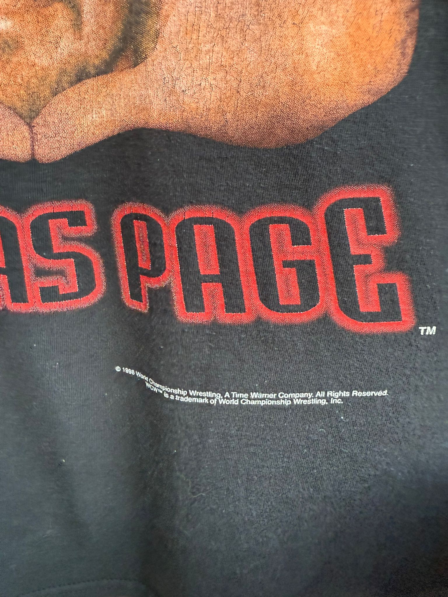 Close up of black t-shirt area showing branding for WCW 1998