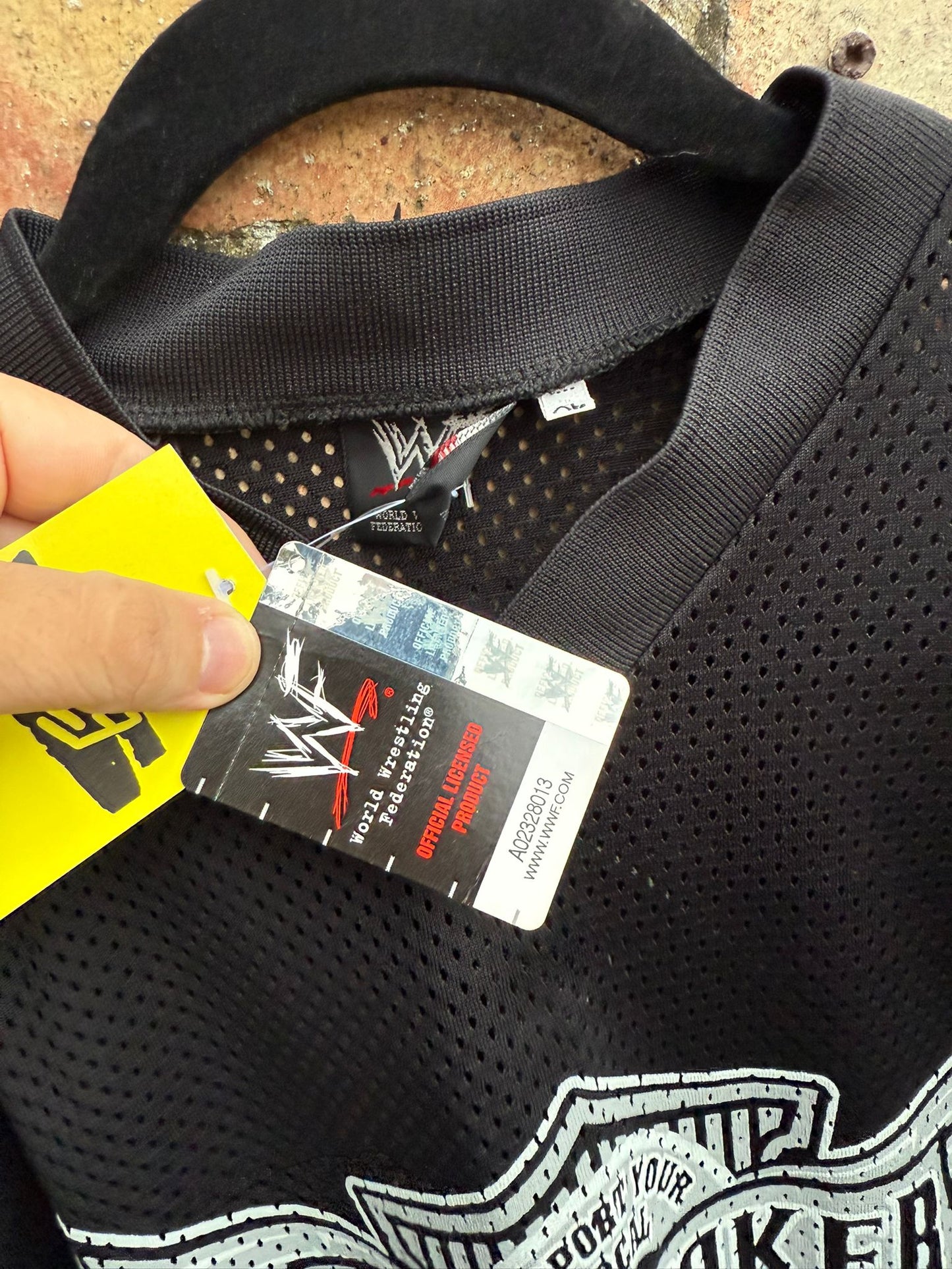 Close-up of WWF clothes tag on Undertaker black jersey