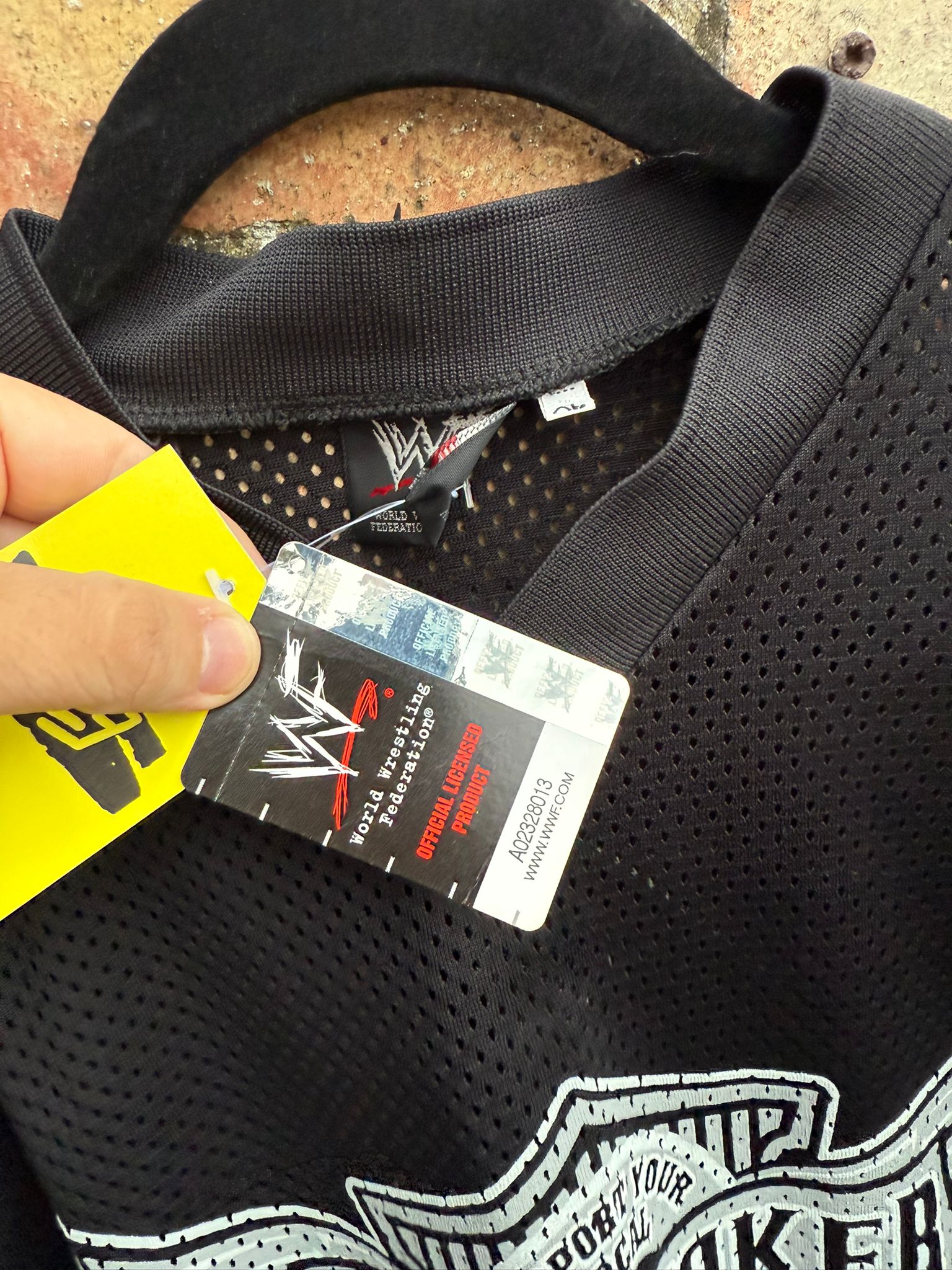 Close-up of WWF clothes tag on Undertaker black jersey