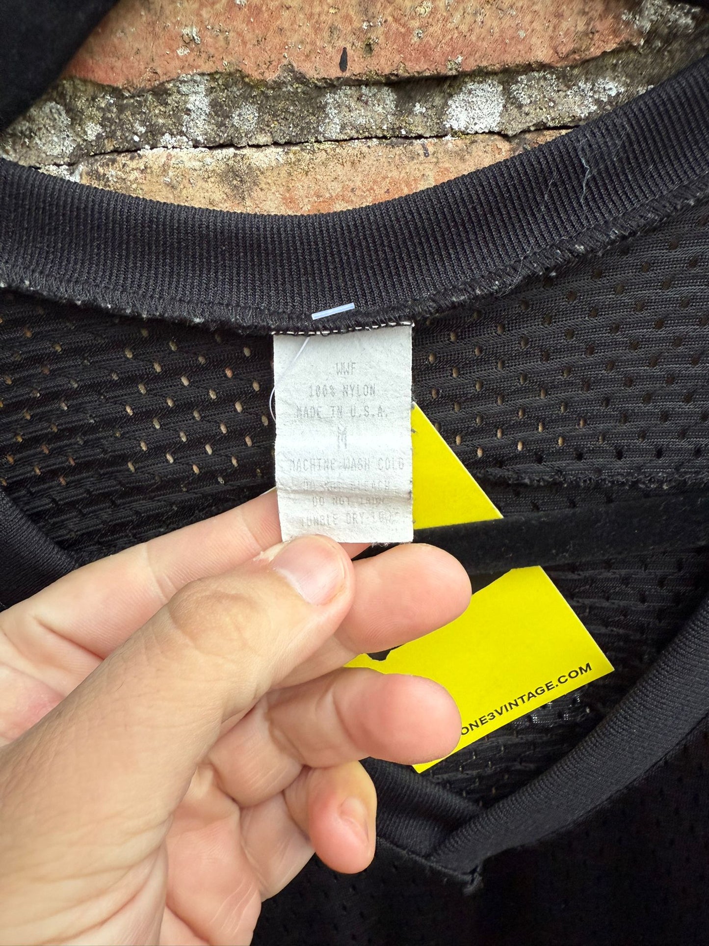 Close-up of a WWF tag size M on a black jersey
