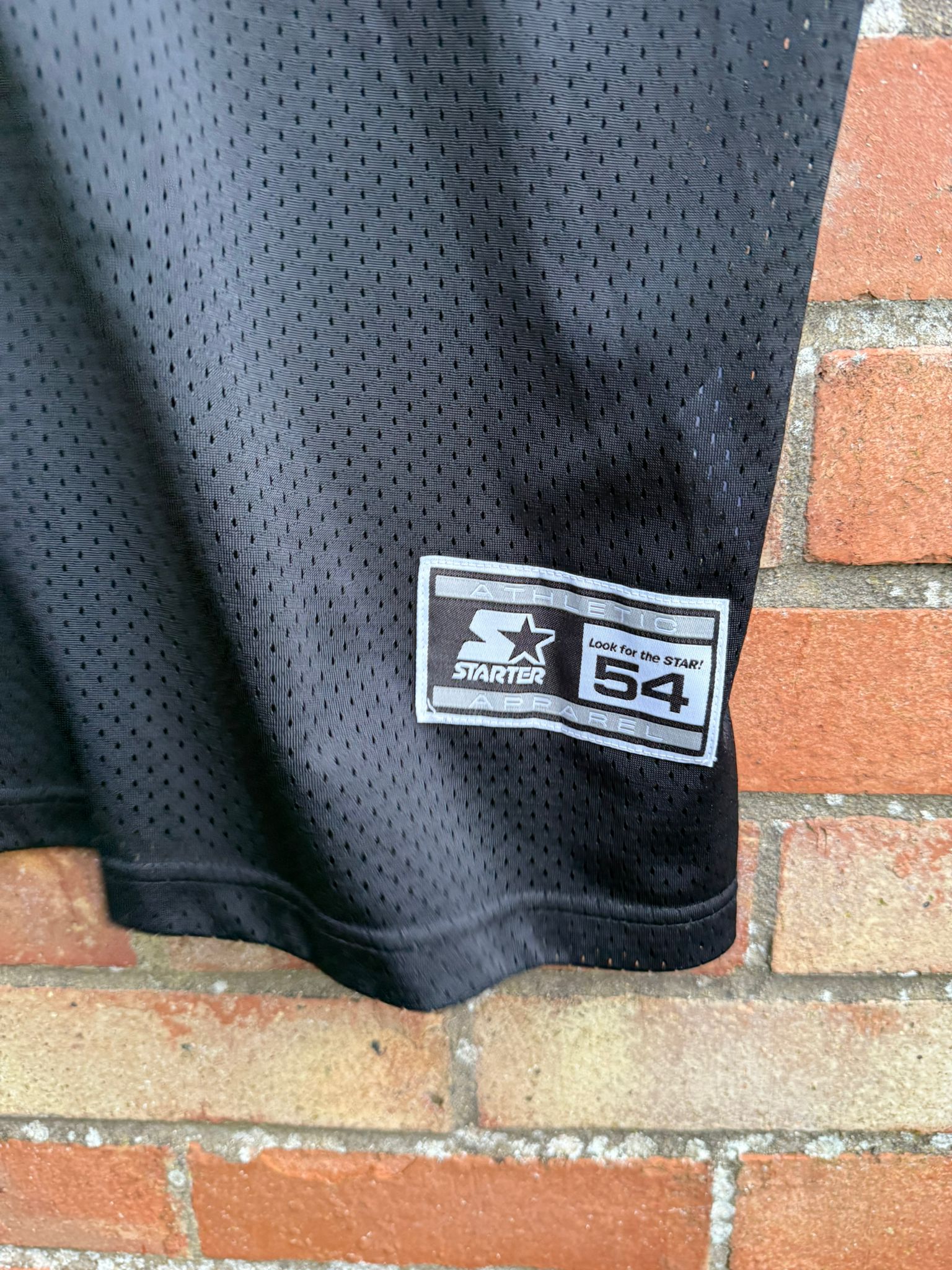 Black mesh sports jersey with a Starter logo
